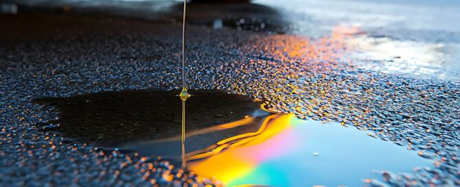 Eures • Öl tropft unter einem geparkten Auto auf Asphalt.
