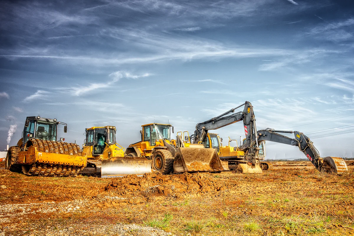 Eures • Baugeräte auf einer Baustelle unter blauen Himmel.