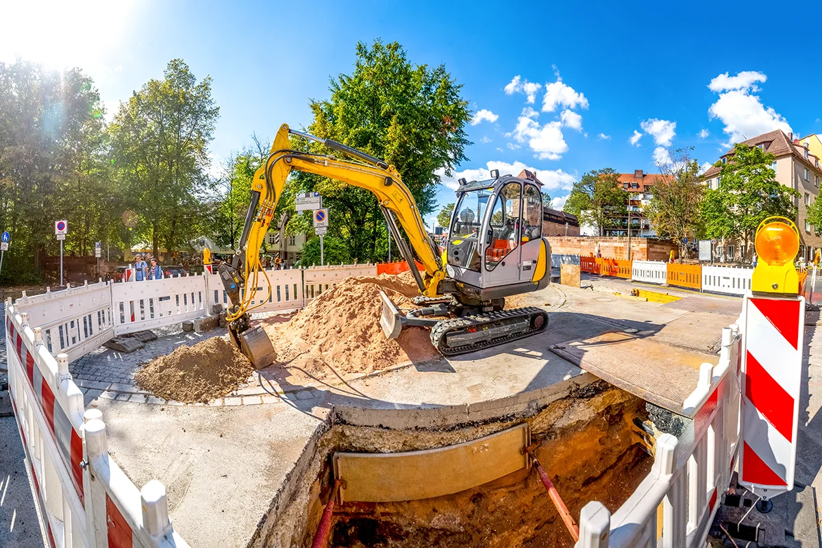 eures-unfallstellensanierung-2 Eures • Bauarbeiten mit Bagger auf einer Straße an einem sonnigen Tag.