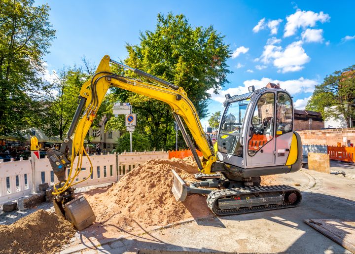 unfallstellensanierung-start Eures • Gelber Bagger auf Baustelle mit Sandhügel und Baustellenabsperrung.